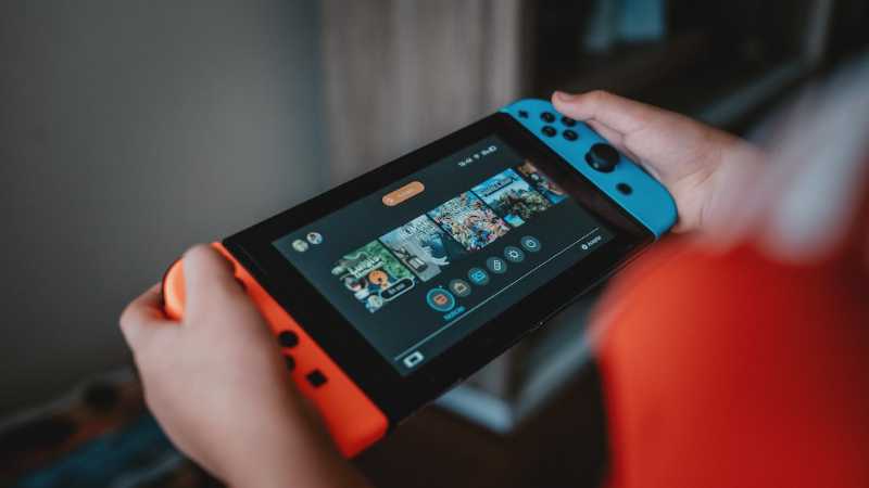 person holding black and orange nintendo switch - Nintendo Switch!, tags: mar10 day choose game - unsplash